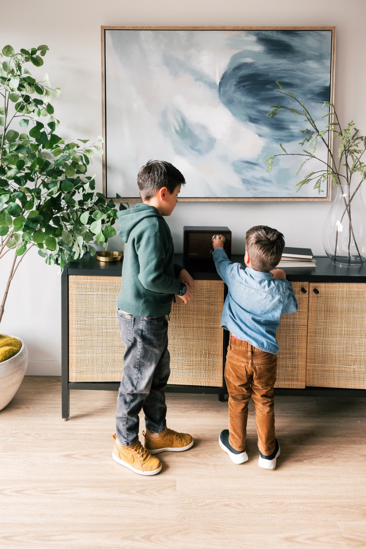 Two children exploring a bright, well-kept apartment living room